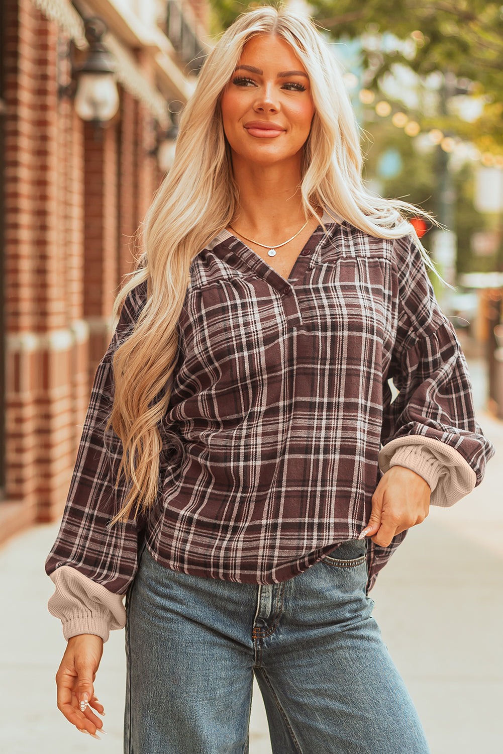 Brown plaid hooded top with a collar and half-button placket, worn with jeans