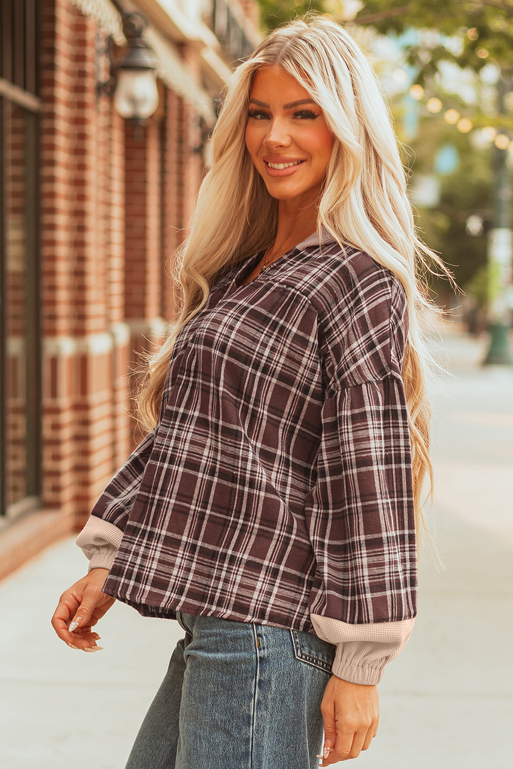 Three-quarter view of the brown plaid hooded top