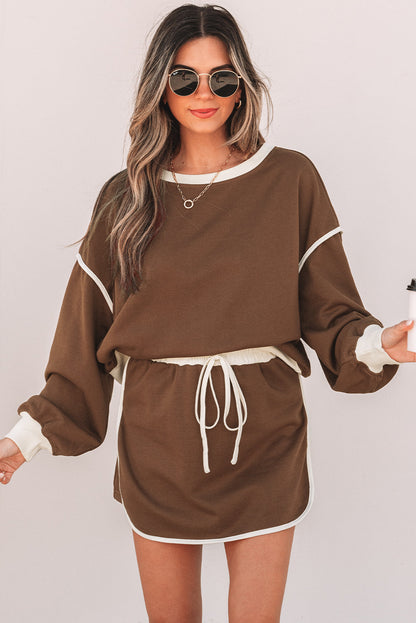 Coffee brown pullover and skort set with cream piping on a model