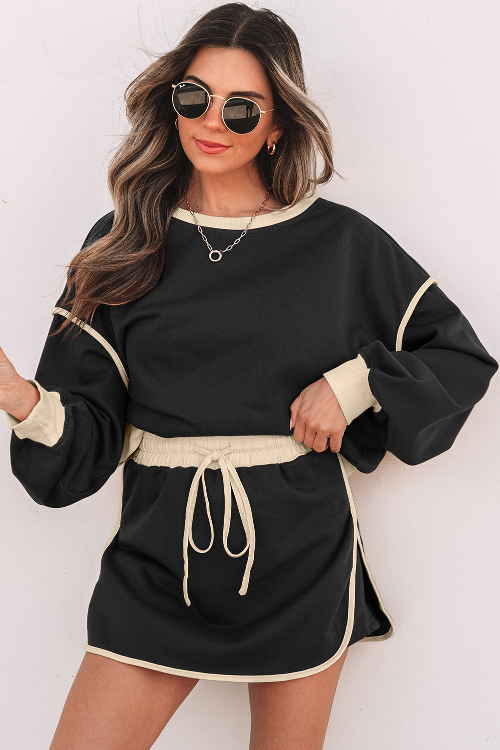 Black pullover and skort set with cream piping on a model