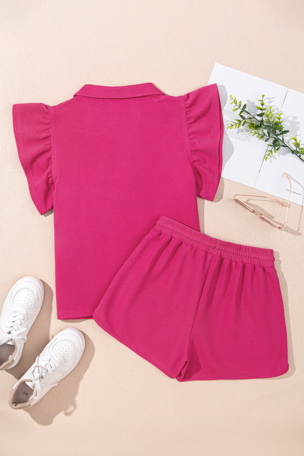 Hot pink flutter sleeve top and shorts laid flat, back view