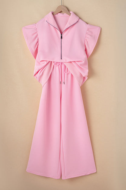 Pink quarter-zip top and wide-leg pants set on a hanger