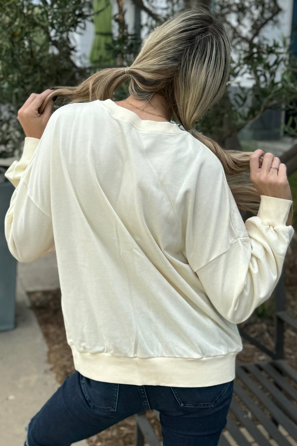 Back view of the cream rainbow sweatshirt