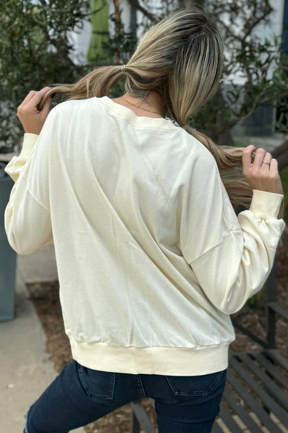 Back view of the cream rainbow sweatshirt