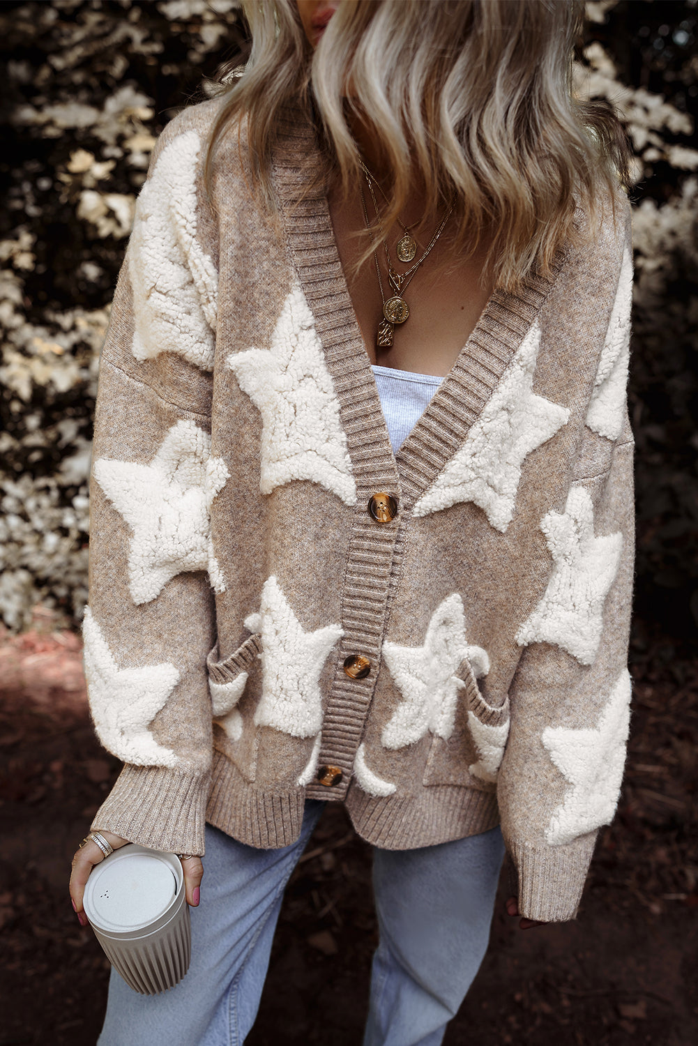 Khaki sherpa star cardigan buttoned over jeans, front view, model holding a coffee cup
