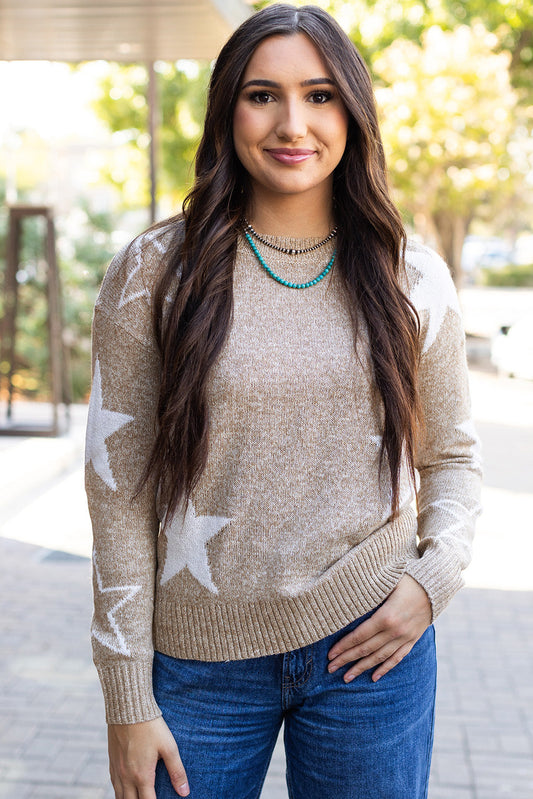 Oatmeal star sweater with white stars on the sleeves, worn with jeans, front view