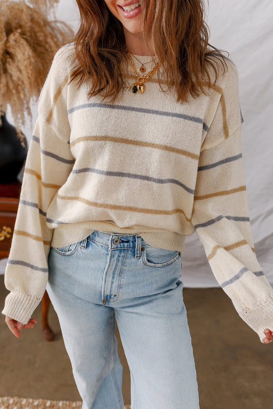 Cream sweater with thin mustard and gray stripes, worn with light jeans, front view