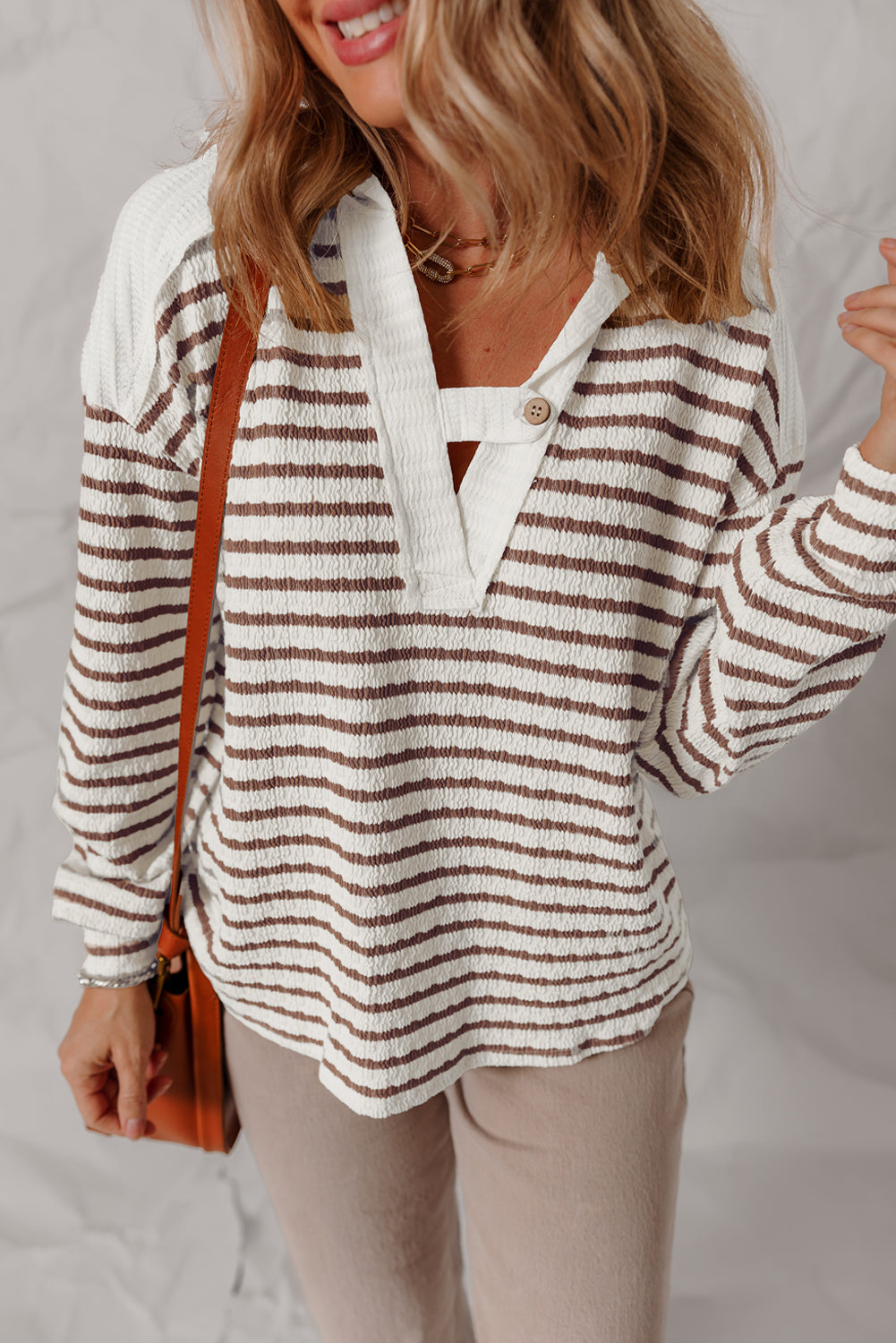 Striped hooded top with a buttoned V-neck tab, front view