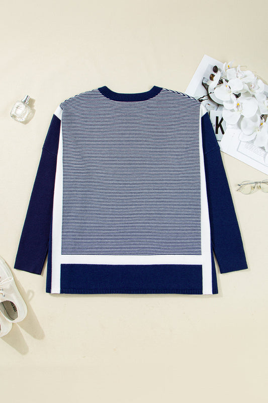 Navy and white pinstripe tunic sweater laid flat, navy sleeves and color-block hem bands