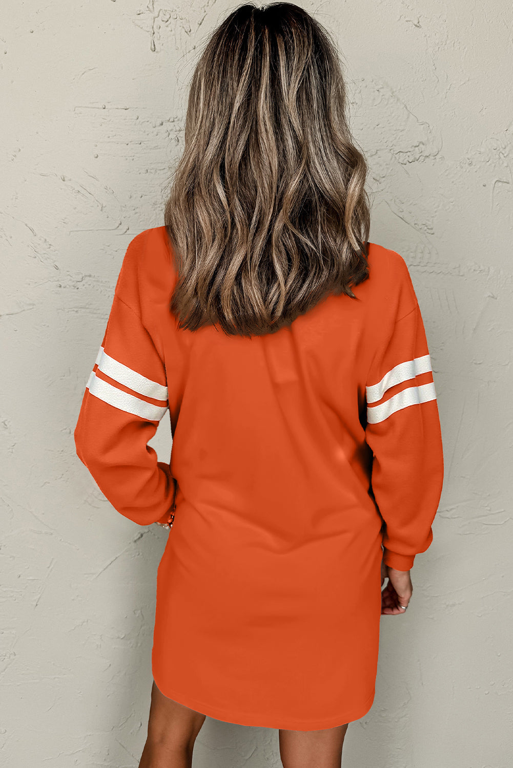 Back view of the orange varsity stripe sweatshirt dress