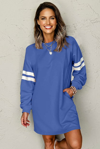 Blue sweatshirt dress with white varsity stripes on a model