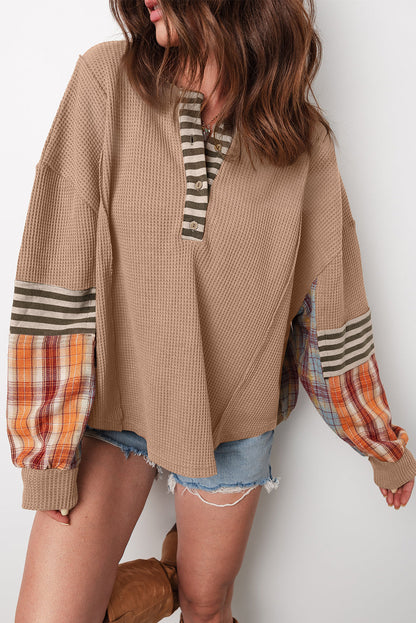 Tan waffle knit henley top with plaid patchwork sleeves, front view